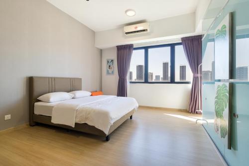 een slaapkamer met een bed en een groot raam bij Encorp Strand Residences by Airhost in Kota Damansara