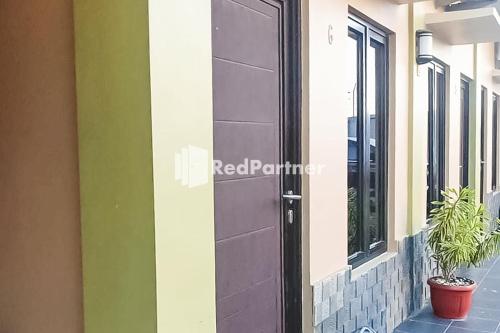 a black door on the side of a building at Ardico Residence Syariah Mitra RedDoorz in Poponcal 2