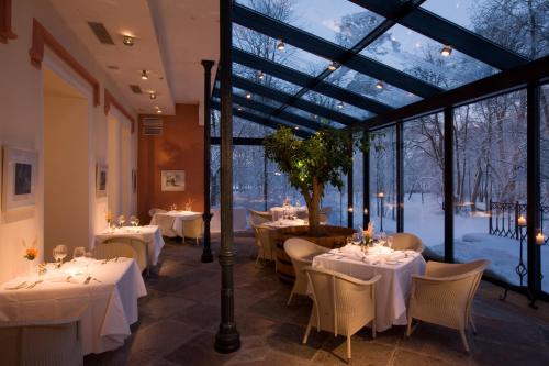 帕達斯特的住宿－帕達斯特莊園酒店，餐厅设有白色的桌椅和窗户。