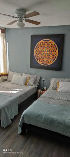 a bedroom with two beds and a ceiling fan at Casa Armony in Cuernavaca