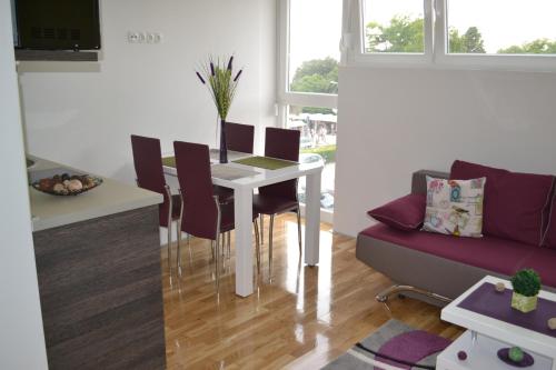ein Wohnzimmer mit einem Tisch und einem Sofa in der Unterkunft Apartments Zadar 4 You in Zadar
