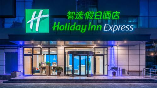 青島市にあるHoliday Inn Express Qingdao City Center, an IHG Hotelのホリデーインエクスプレスを読む看板のある建物