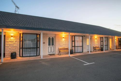 a building with a parking lot in front of it at Coronation Park Holiday Park in Ashburton