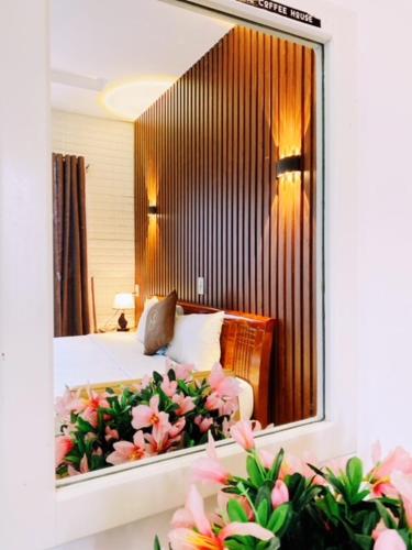 a bedroom with a mirror and a bed with flowers at Poetic Hue Hotel & Spa in Hue