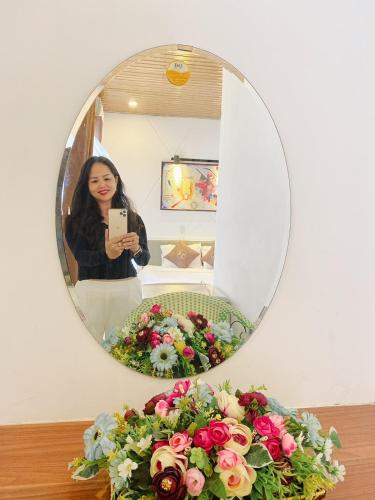a woman taking a picture of herself in a mirror at Poetic Hue Hotel & Spa in Hue