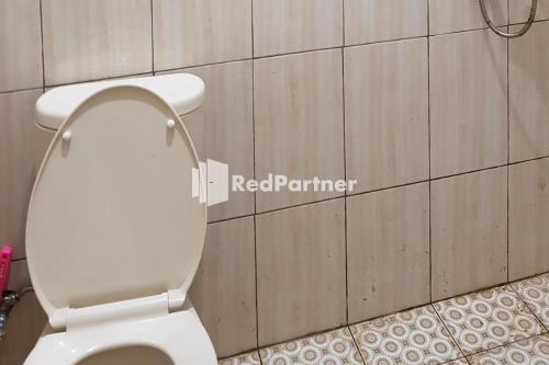 a bathroom with a white toilet in a room at Homestay Lotus Bangka Mitra RedDoorz in Pangkal Pinang