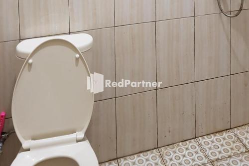 a bathroom with a white toilet in a room at Homestay Lotus Bangka Pangkal Pinang RedPartner in Pangkalpinang