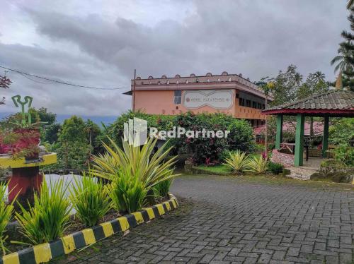 a building with a red palmer sign in front of it at Hotel Makatembo Tomohon Mitra RedDoorz in Pineleng