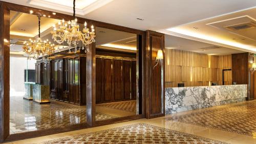 a lobby with a chandelier and a hallway with a counter at Le'venue Hotel in Bangi