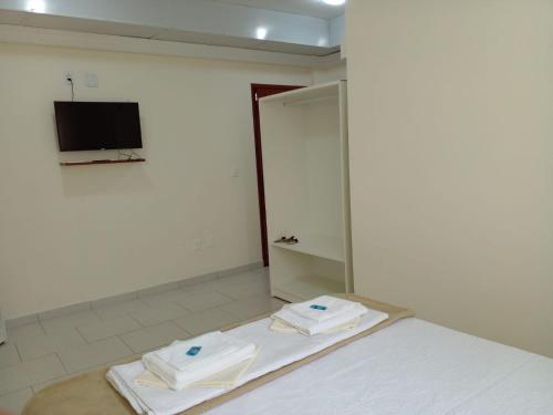 a room with a bed with towels on it at Riachuelo Hotel in Resende