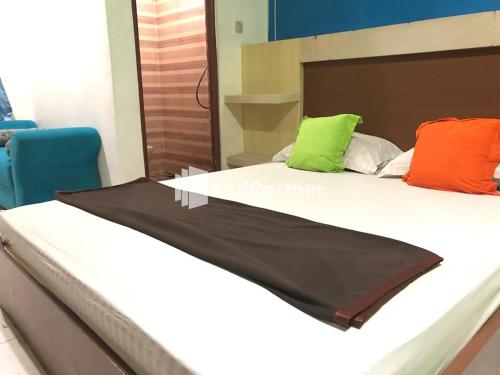 - un lit avec des oreillers colorés dans l'établissement Seungit Syariah Inn Tebet Mitra RedDoorz, à Jakarta