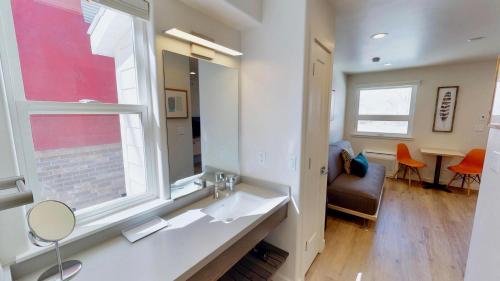 baño con lavabo, ventana y silla en Slot Canyon #C, en Moab