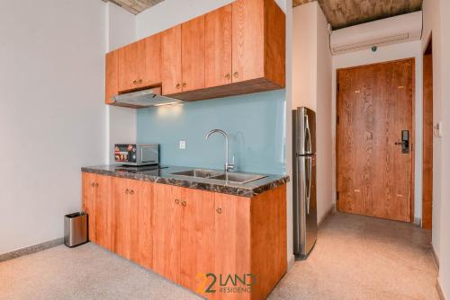 a kitchen with wooden cabinets and a sink and a door at 22Land Hotel & Residence in Hanoi