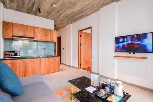a living room with a couch and a tv on a wall at 22Land Hotel & Residence in Hanoi