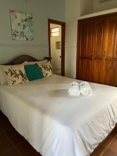 a white bed with two towels on top of it at Casa Isabelita in Mompos