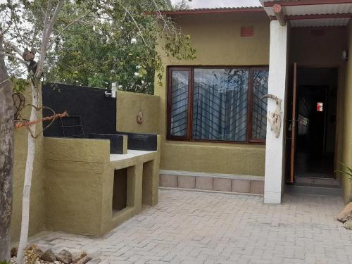 a house with a concrete counter in front of a door at Ann's Lodge & Camping in Kamanjab