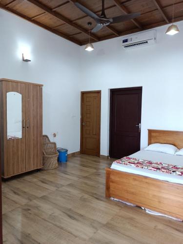 a bedroom with a bed and a wooden floor at Beach Nest in Kannur