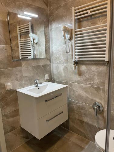 ein Badezimmer mit einem weißen Waschbecken und einem Spiegel in der Unterkunft Hannover Zimmervermietung Mardino in Hannover