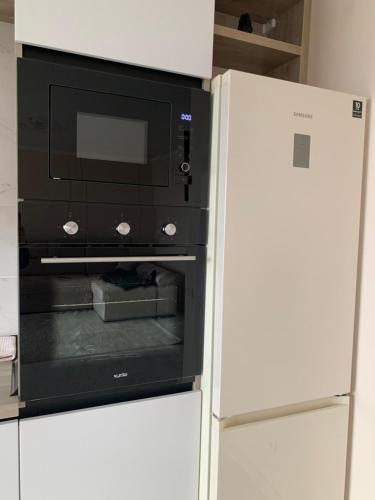 a microwave oven in a kitchen next to a refrigerator at River Apartments in Vinnytsya