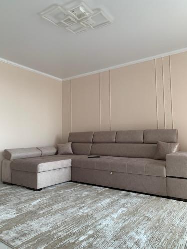 a living room with a brown couch in a room at River Apartments in Vinnytsya