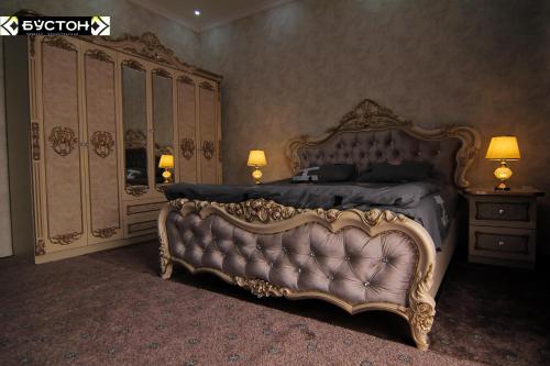 a bedroom with a king sized bed and a dresser at Hotel Buston in Chkalovsk