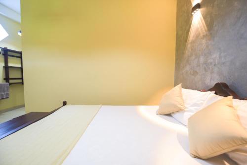 a bed with white sheets and pillows in a room at Traveller's Villa in Hatton