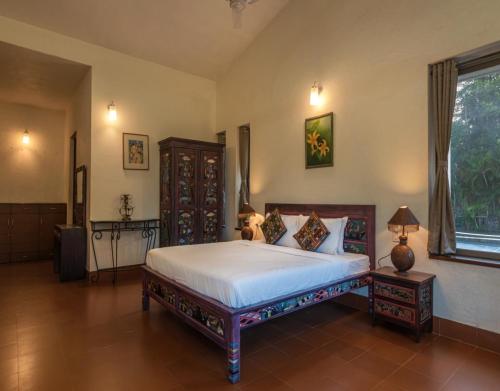 a bedroom with a large bed and a window at SaffronStays Aurelia, Panchgani - Balinese villa with breathtaking valley views in Panchgani
