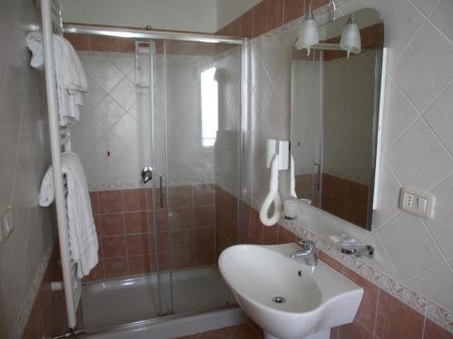 a bathroom with a sink and a shower and a mirror at Hotel Sirena in Castellabate