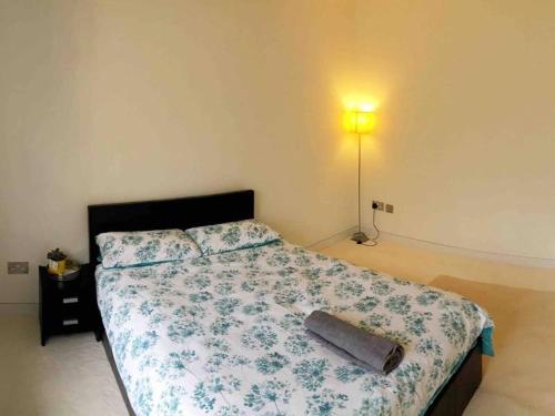 a bedroom with a bed with a blanket and a lamp at Double Bedroom, Kings Lynn, New Renovated Bathroom in King's Lynn