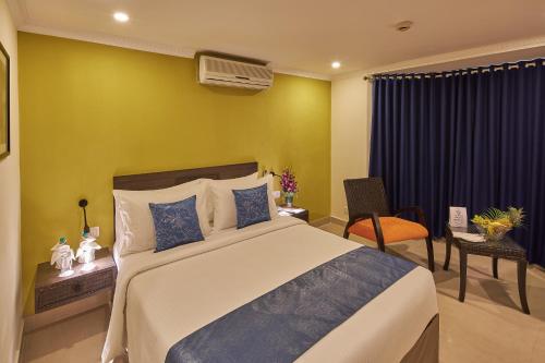a bedroom with a large bed with a yellow wall at Tulip Inn Koramangala Bangalore in Bengaluru