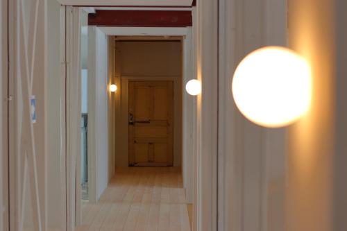 a hallway with a door and a light fixture at Square 8 HAKUBA RETREAT by UNPLAN in Hakuba