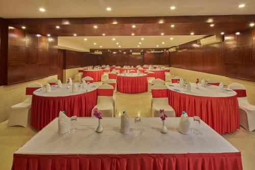a large banquet hall with red and white tables and chairs at Tulip Inn Koramangala Bangalore in Bengaluru