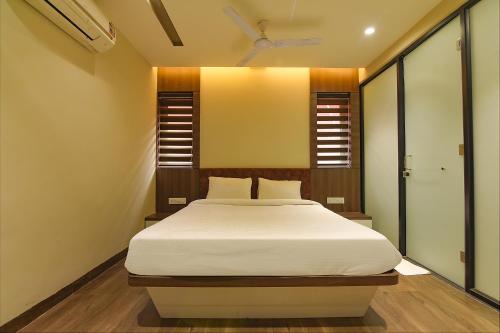 a bedroom with a large bed with white sheets at FabHotel Eros 282 in Kolkata