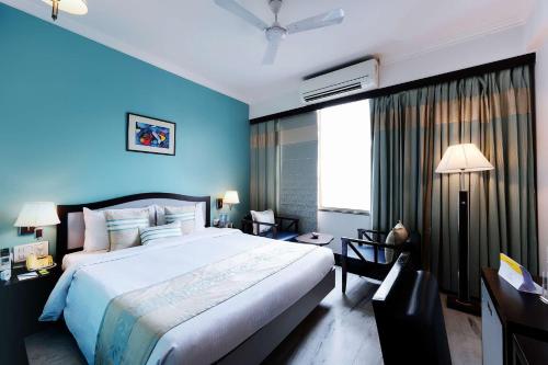 a bedroom with a large bed and a blue wall at Capitol Residency in Rānchī