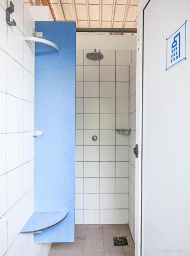 La salle de bains est pourvue d'une douche avec un mur bleu. dans l'établissement Camping de Tournus - Drole de cabane, à Tournus