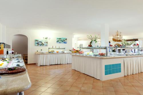 a large kitchen with counters and tables in a room at Sentido Orosei Beach in Orosei