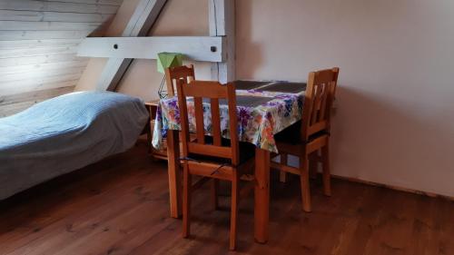 a room with a table and two chairs and a bed at Czarna Jachta - Na szlaku legend - - - - - Pokoje nad jeziorem in Kruklanki