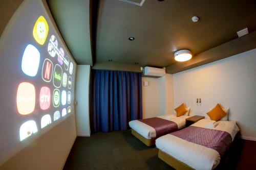 a hotel room with two beds and a large window at Hotel S-Presso West in Osaka