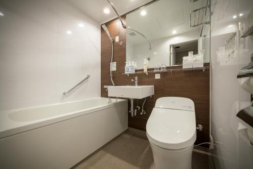 ein Badezimmer mit einem weißen WC und einem Waschbecken in der Unterkunft Hotel Royal Morioka in Morioka
