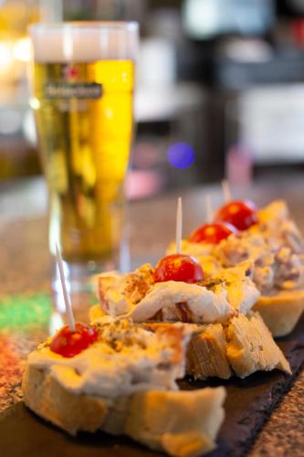 a table with some food and a glass of beer at Domus Oncinae in Oncina de la Valdoncina