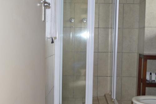 a bathroom with a shower and a toilet at Hotel @ Tzaneen in Tzaneen