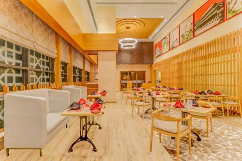 a restaurant with tables and chairs in a room at Lemon Tree Premier, Bhubaneswar in Bhubaneshwar