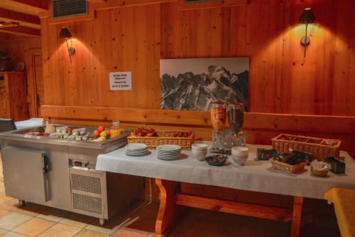 een keuken met een tafel met eten erop bij Chalet-Hôtel de l'Etape in Les Contamines-Montjoie