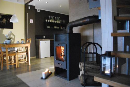 a wood stove with two candles in a living room at Szarejkowe Wzgórza in Szarejki