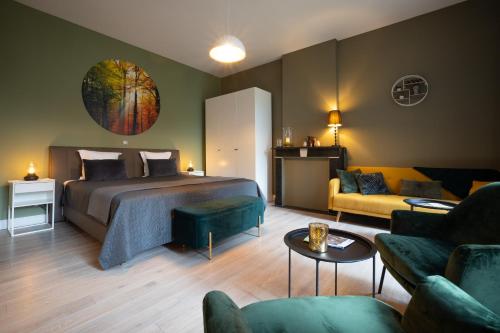 a bedroom with a bed and a couch and a table at B&B Gaudium XII in Tongeren