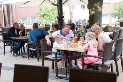 a group of people sitting at a table in a restaurant at Hotel Greive in Haren