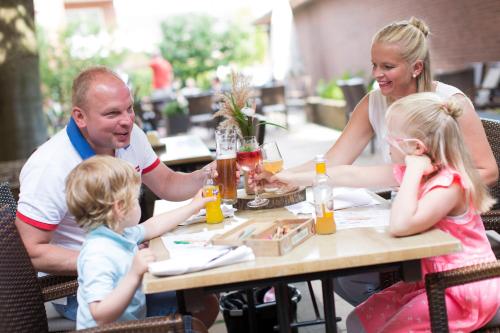 a family sitting at a table at a restaurant at Hotel Greive in Haren