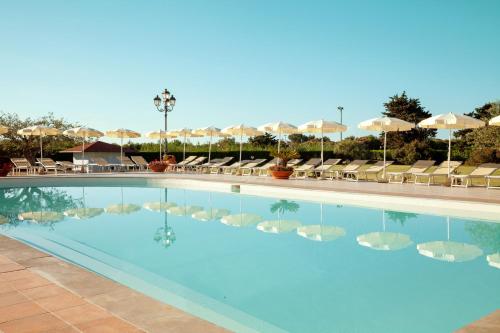 a pool at a hotel with chairs and umbrellas at Sentido Orosei Beach in Orosei