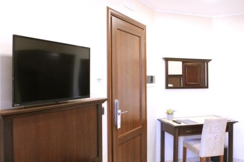 a flat screen tv sitting on top of a wooden entertainment center at Le Corti - Dimora storica in Polistena