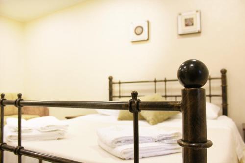 a bed with white sheets and a metal rail at Le Corti - Dimora storica in Polistena